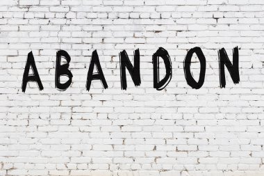 Beyaz tuğla duvara yazıt terk edilmiş.