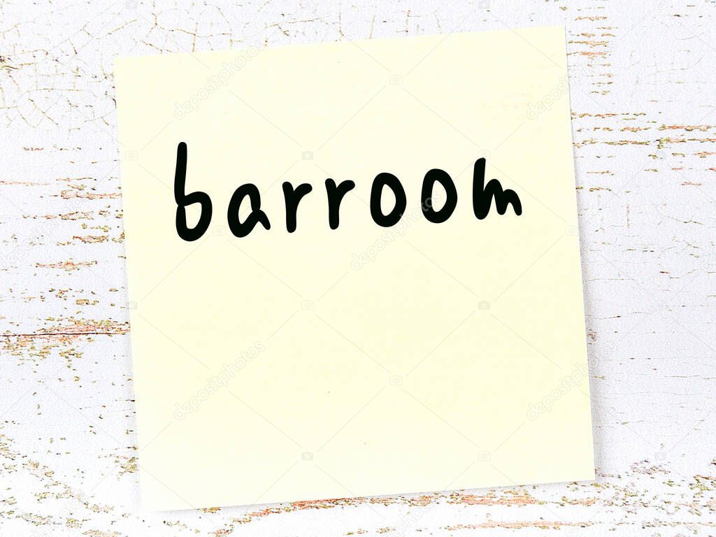 Yellow sticky note on wooden wall with handwritten word barroom