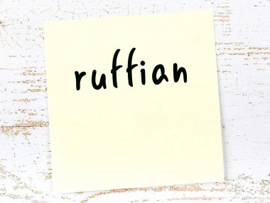 Ahşap duvarda el yazısıyla yazılmış sarı yapışkan bir not.