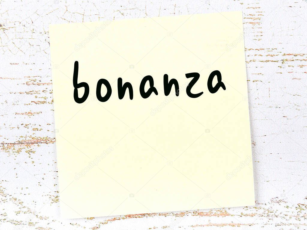 Yellow sheet of paper with word bonanza. Reminder concept