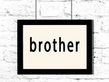 Beyaz tuğla duvarda asılı siyah çerçeve ve yazıt kardeşim