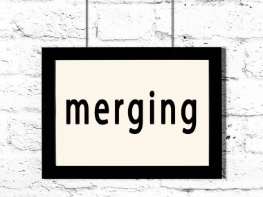 Beyaz tuğla duvarda asılı siyah çerçeve ve yazı birleşimi