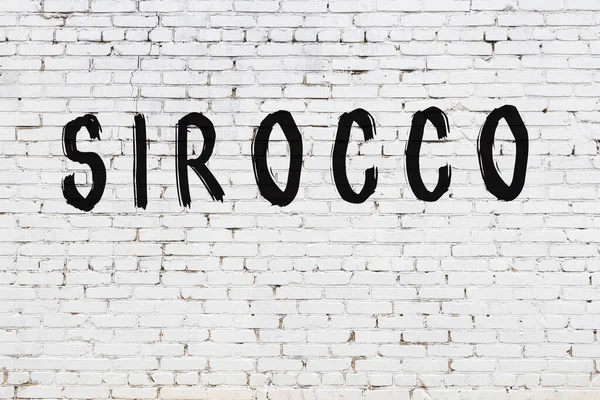 Üzerinde siyah boya sirokosu olan beyaz bir duvar.