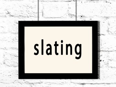 Beyaz tuğla duvarda asılı siyah çerçeve.