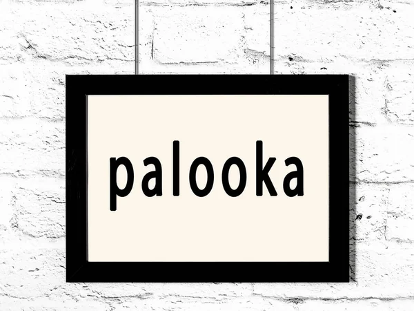 碑文palookaと白いレンガの壁にぶら下がっている黒いフレーム — ストック写真