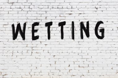 Üzerinde siyah boya yazan beyaz bir duvar.