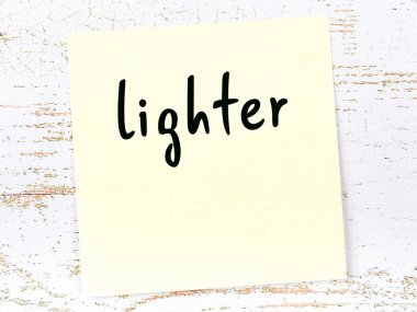 Tahta duvardaki sarı yapışkan nota, el yazısıyla yazılmış çakmak.