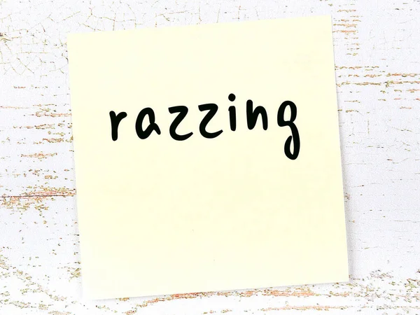 Hoja amarilla de papel con la palabra razzing. Concepto de recordatorio — Foto de Stock