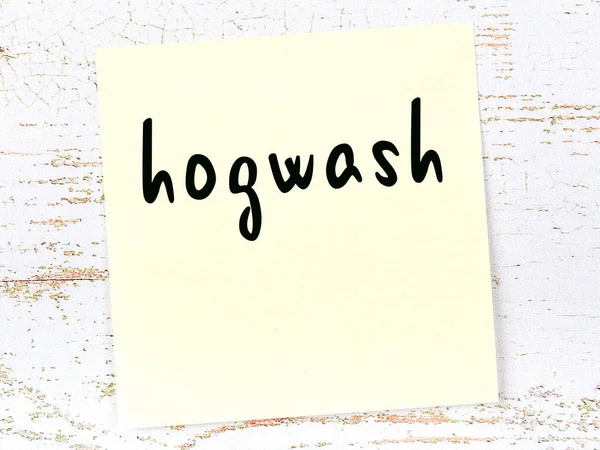 Nota pegajosa amarela na parede de madeira com hogwash palavra manuscrita — Fotografia de Stock