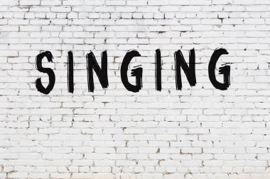 Üzerinde siyah boya yazılı beyaz duvar şarkı söylüyor.