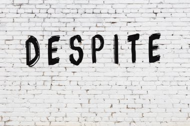 Beyaz tuğla duvardaki yazıtlara rağmen