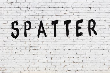 Beyaz tuğla duvara yazı sıçramış.