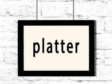 Beyaz tuğla duvarda asılı siyah çerçeve yazı tabağıyla