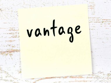 Tahta duvarda el yazısıyla yazılmış sarı yapışkan bir not var.