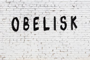 Üzerinde siyah boyalı dikilitaş olan beyaz duvar.