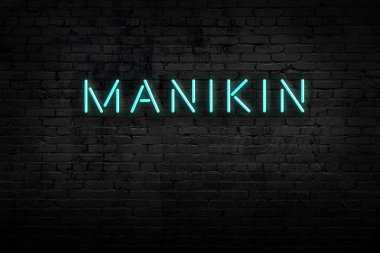 Neon işareti. Kelime manikini tuğla duvara karşı. Gece görünümü