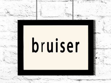 Beyaz tuğladan duvara asılmış siyah çerçeve.