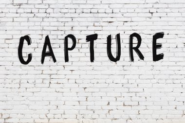 Beyaz tuğla duvara yazılmış bir yazı.