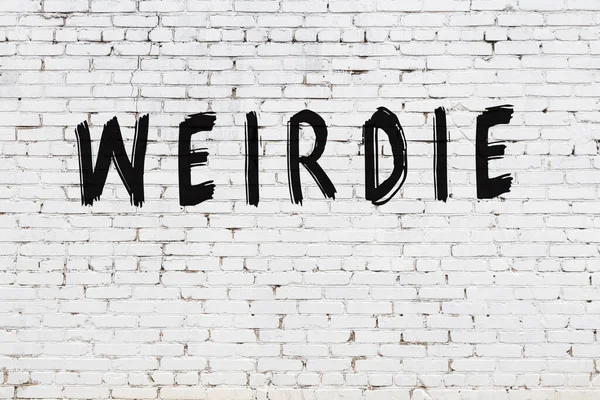 White wall with black paint inscription weirdie on it — Stock Photo, Image