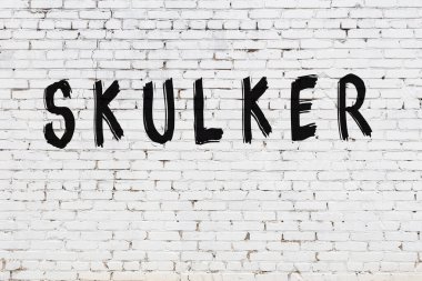 Üzerinde siyah boya yazıları olan beyaz duvar.