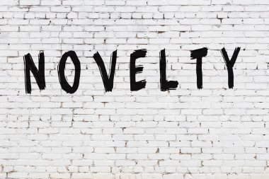 Üzerinde siyah boya yazıları olan beyaz bir duvar.