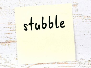 Tahta duvarda el yazısıyla yazılmış sakalı olan sarı yapışkan bir not.