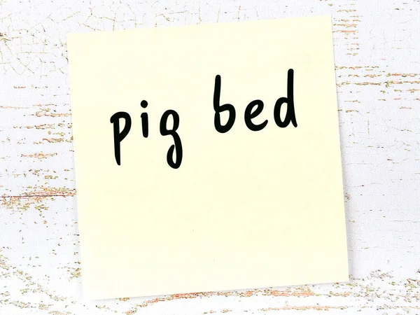 Yellow sheet of paper with word pig bed. Reminder concept — Stock Photo, Image