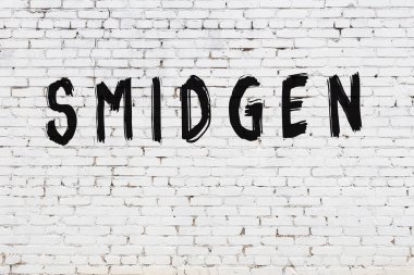 Beyaz tuğla duvara küçük harflerle yazılmış.