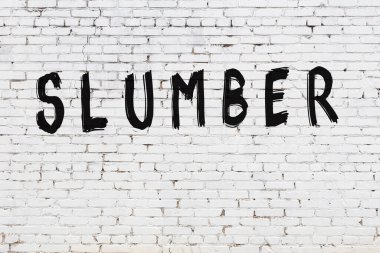 Üzerinde siyah boya yazılı beyaz duvar uyukluyor.