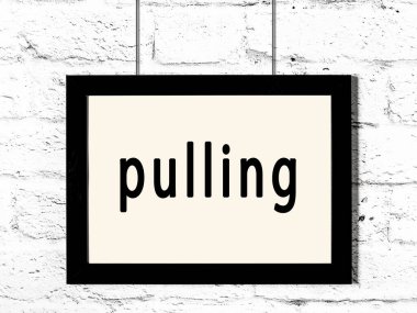 Beyaz tuğla duvarda asılı duran siyah çerçeve.