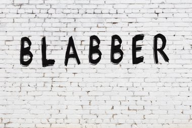 Üzerinde siyah boya yazıları olan beyaz duvar.