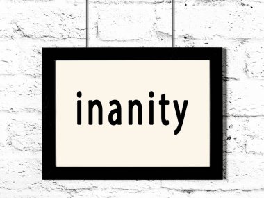 Beyaz tuğla duvarda asılı siyah çerçeve.