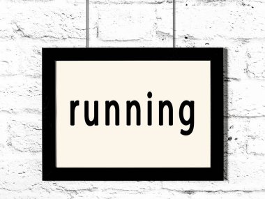 Beyaz tuğla duvarda asılı siyah çerçeve ve yazı çalışıyor