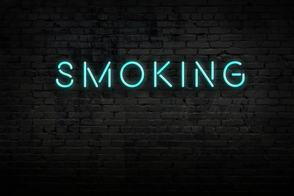 Нічний вигляд неонового знака на цегляній стіні з написом куріння — стокове фото