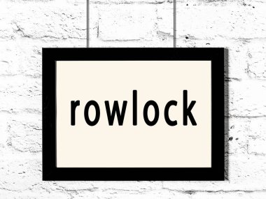 Beyaz tuğla duvarda asılı siyah çerçeve ve yazıt rowlock