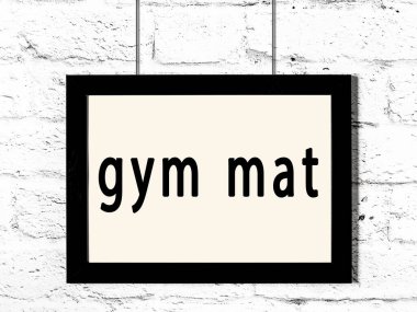 Beyaz tuğladan duvara asılı siyah çerçeve ve spor salonu paspası