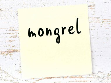 Tahta duvardaki sarı yapışkan notta el yazısıyla yazılmış melez bir kelime var.