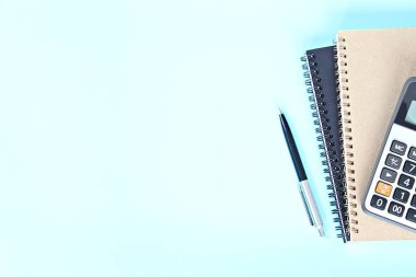 İş, finans, toplantı planlama veya muhasebe kavram: üstten görünüm veya düz yatıyordu defter, kalem ve mavi arka plan kopya ile hesap makinesi uzay hazır eklemek için veya yukarı alay