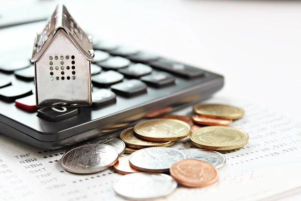 Business, finance, saving money, property ladder or mortgage loan concept : House model, calculator and coins on savings account passbook or financial statements