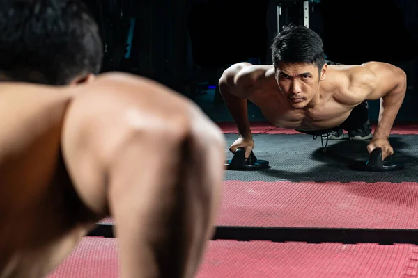 Asian people work out by push-up the floor in  modern gym.