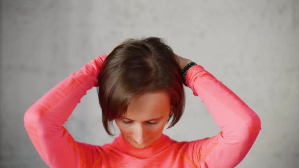 Woman puts hands on back of head and tilts head forward stretching neck muscles. — Stock Footage Woman puts hands on back of head and tilts head forward stretching neck muscles. Royalty Free Stock Video