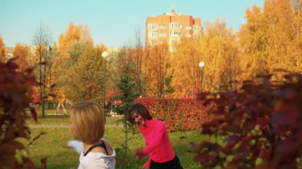 Sportos mosolygós nők táncolnak az őszi parkban