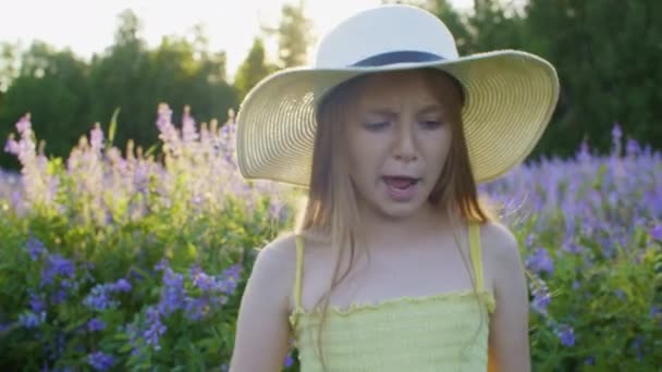 Dívka v klobouku tančí na kvetoucí louce v létě