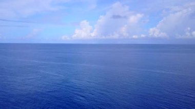 Beyaz kum arka planlı mavi okyanus kıyısındaki cennet lagününün insansız hava manzarası.