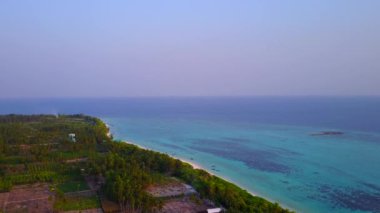 Mavi okyanus ve beyaz kum arka planında sakin turist plajı yaşam tarzının insansız hava aracı yolculuğu