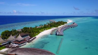 Beyaz kumlu arka planlı sığ okyanus kıyısındaki egzotik lagünün insansız hava aracı manzarası