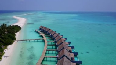 Parlak kum arka planlı turkuaz okyanusla güzel sahil zamanının hava manzarası.