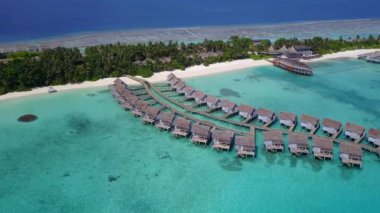 Beyaz kumlu arka planlı mavi deniz kıyısında rahatlatıcı deniz manzarası.