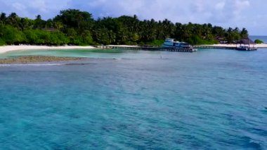 Lüks deniz kıyılarından oluşan insansız hava aracı panoraması beyaz kum arka planlı turkuaz lagün tarafından yıkılıyor.