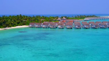 Rahatlatıcı lagünün hava aracı panoraması beyaz kumlu arka planda mavi deniz kıyısında kırılıyor.